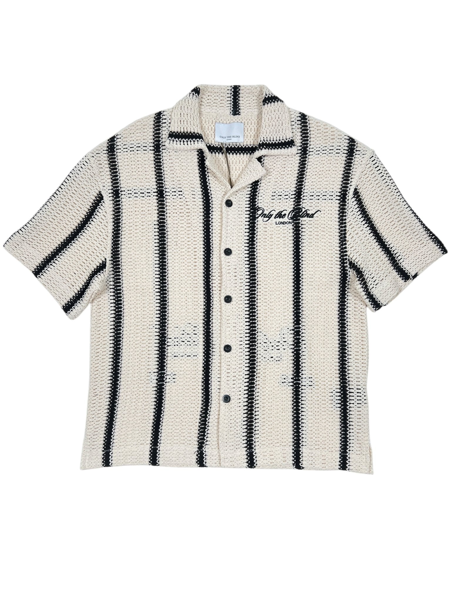The Only The Blind OTB-SH1520 Desert Stripe Crochet Shirt features cream short sleeves, bold black vertical stripes, and front buttons. It showcases the "Only The Blind" embroidered logo on the left chest for a chic blend of style and subtle sophistication.