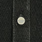 Close-up of a metal button with engraved text on the edge, set on dark, diagonally striped fabric—part of the Probus Only The Blind OTB-SH1572 Noir Heritage Shirt Black.