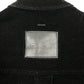 Close-up of the upper back of the Probus Only The Blind OTB-SH1572 Noir Heritage Shirt Black, showing black pinstripes and a rectangular gray leather patch with faint embossed writing.
