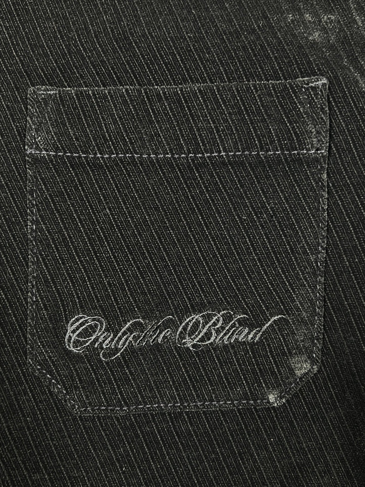 Close-up of a black denim jean pocket with "Oughta Blind" stitched in white cursive, showcasing Probus’s Only The Blind OTB-SH1572 Noir Heritage Shirt Black.