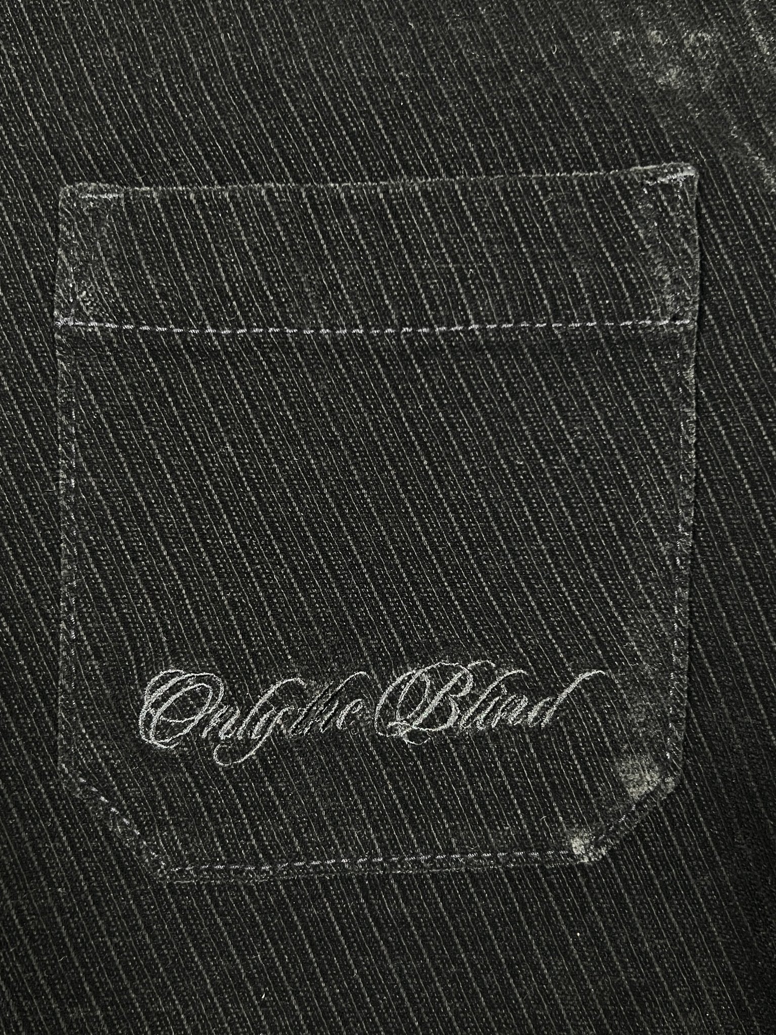 Close-up of a black denim jean pocket with "Oughta Blind" stitched in white cursive, showcasing Probus’s Only The Blind OTB-SH1572 Noir Heritage Shirt Black.
