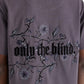 Back view of a person wearing a purple Only The Blind OTB-T1383 Wildflower T-Shirt with intricate blackberry floral embroidery and "only the blind" text.