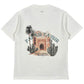The Only The Blind OTB-T1486 Palais Taysir T-shirt in beige features organic cotton, an illustrated scene of an arched building, cacti, palm trees, and "PALAIS TAYSIR" and "RUE DE LA LIBERTE" text on the back.
