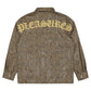 The Pleasures Anaconda Overshirt Brw features a brown anaconda-print design with "PLEASURES" in bold yellow letters across the upper back, creating a striking style.
