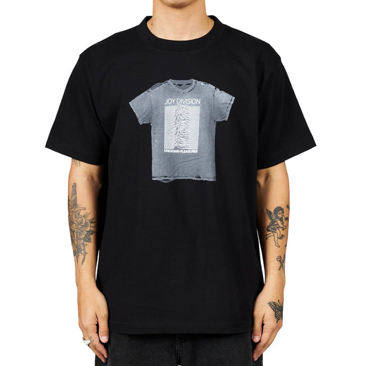 Person wearing a black cotton t-shirt with the PLEASURES 'Unknown Pleasures' album cover graphic, officially screen printed in collaboration with Joy Division.
