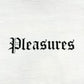 The Pleasures Burn Again T-shirt in white by PLEASURES features "Pleasures" in black Gothic-style print across the chest, crafted from garment dyed cotton for a soft, premium feel.