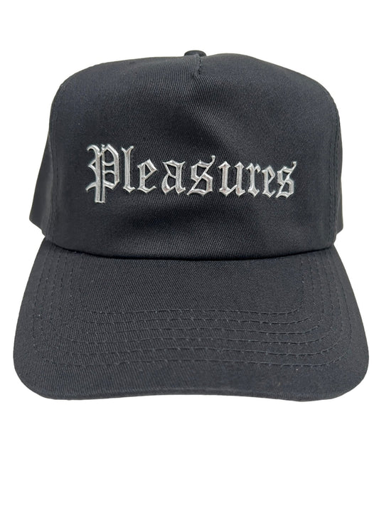 PLEASURES CHROME SNAPBACK BLACK by PLEASURES with "PLEASURES" written in white Gothic-style font on the front.