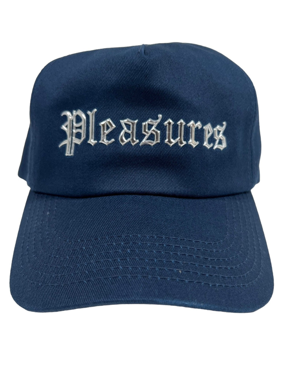 The PLEASURES CHROME SNAPBACK NAVY is crafted with durable Polyester and Nylon, showcasing "Pleasures" embroidered in white Gothic script on the front.