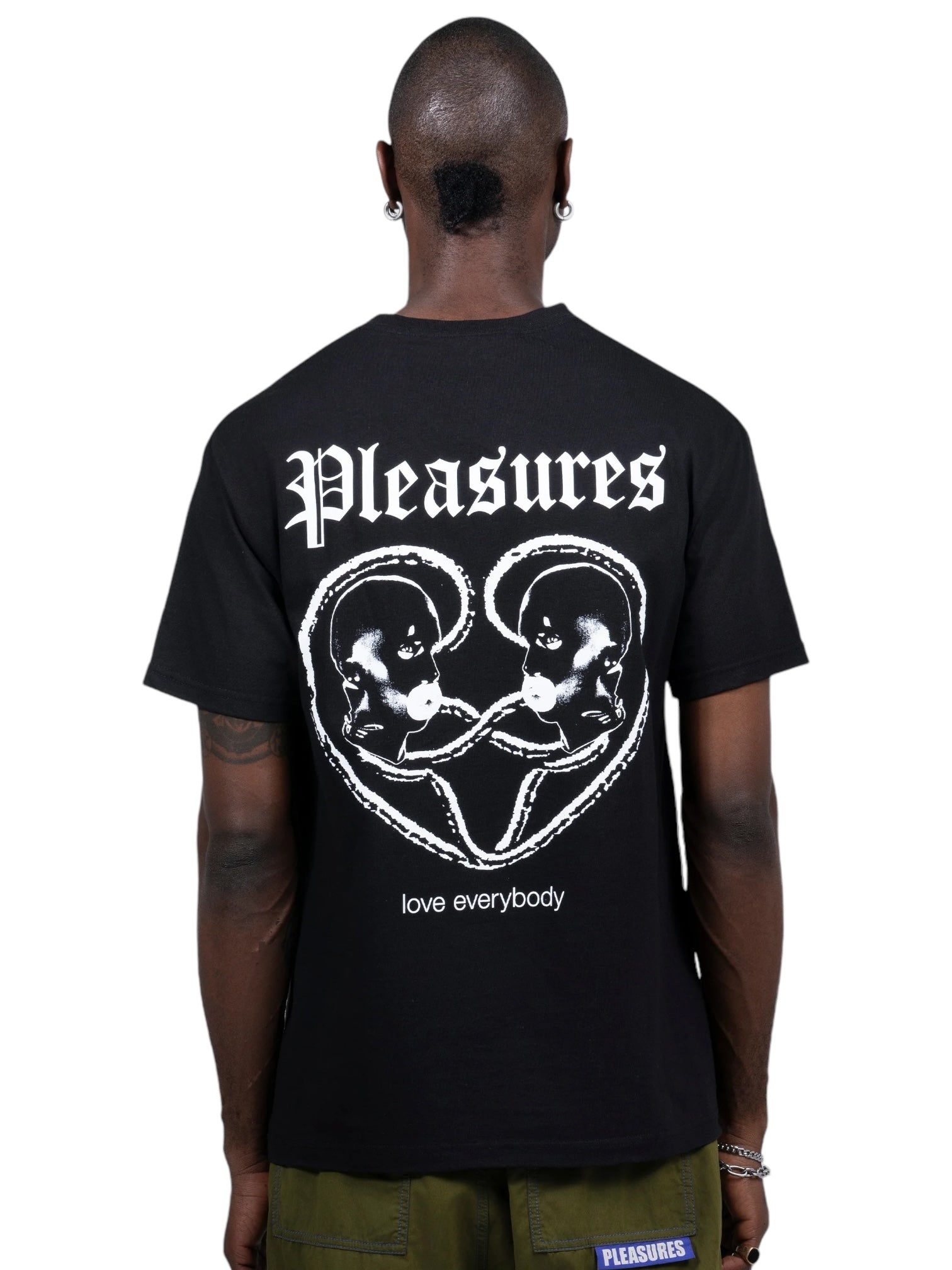 Someone sports a Pleasures Connected T-shirt in black, made from soft cotton. It features "love everybody," "Pleasures," and a white graphic of two faces facing each other, exuding love and positivity.