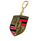 Gold and black PLEASURES Fast Life Keychain Multi with a shield design features a horse, red and black stripes, and text celebrating life's small elegant pleasures.