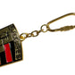 A close-up of the Pleasures Fast Life Keychain Multi from PLEASURES displays a metallic emblem with embossed designs, highlighted by red and black accents, offering small pleasures for the discerning eye.