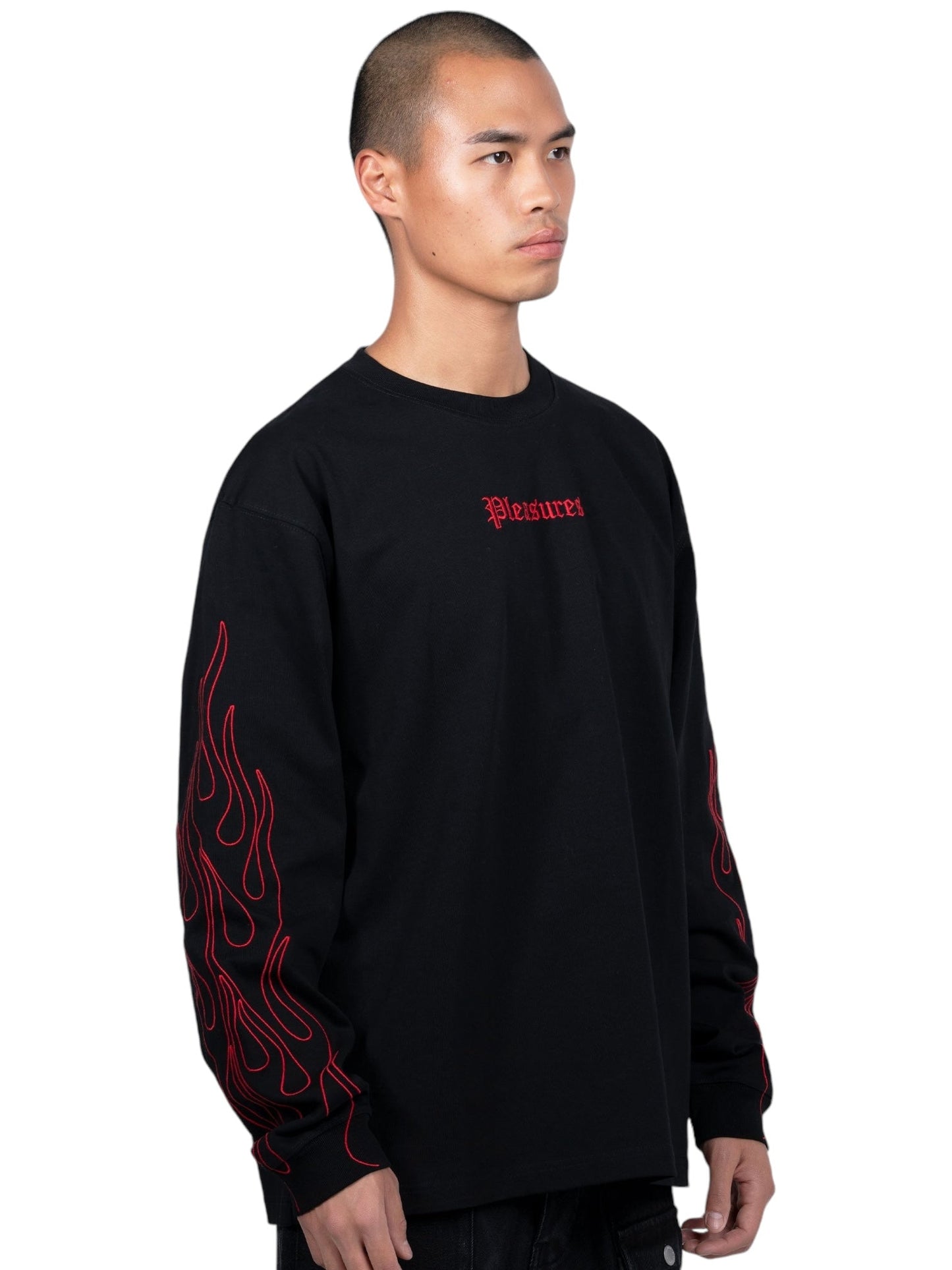 The PLEASURES Fiery Heavyweight L/S T-shirt in Black showcases bold red flames on the arms and vibrant red text on the front, creating a captivating design.