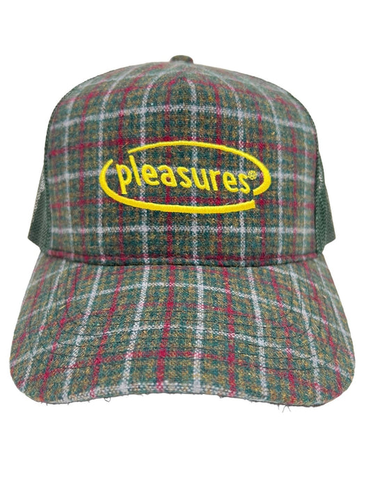 PLEASURES HAPPIER PLAID TRUCKER GREEN with the word "pleasures" in yellow text inside an oval outline on the front, crafted with durable nylon and polyester fabrics.