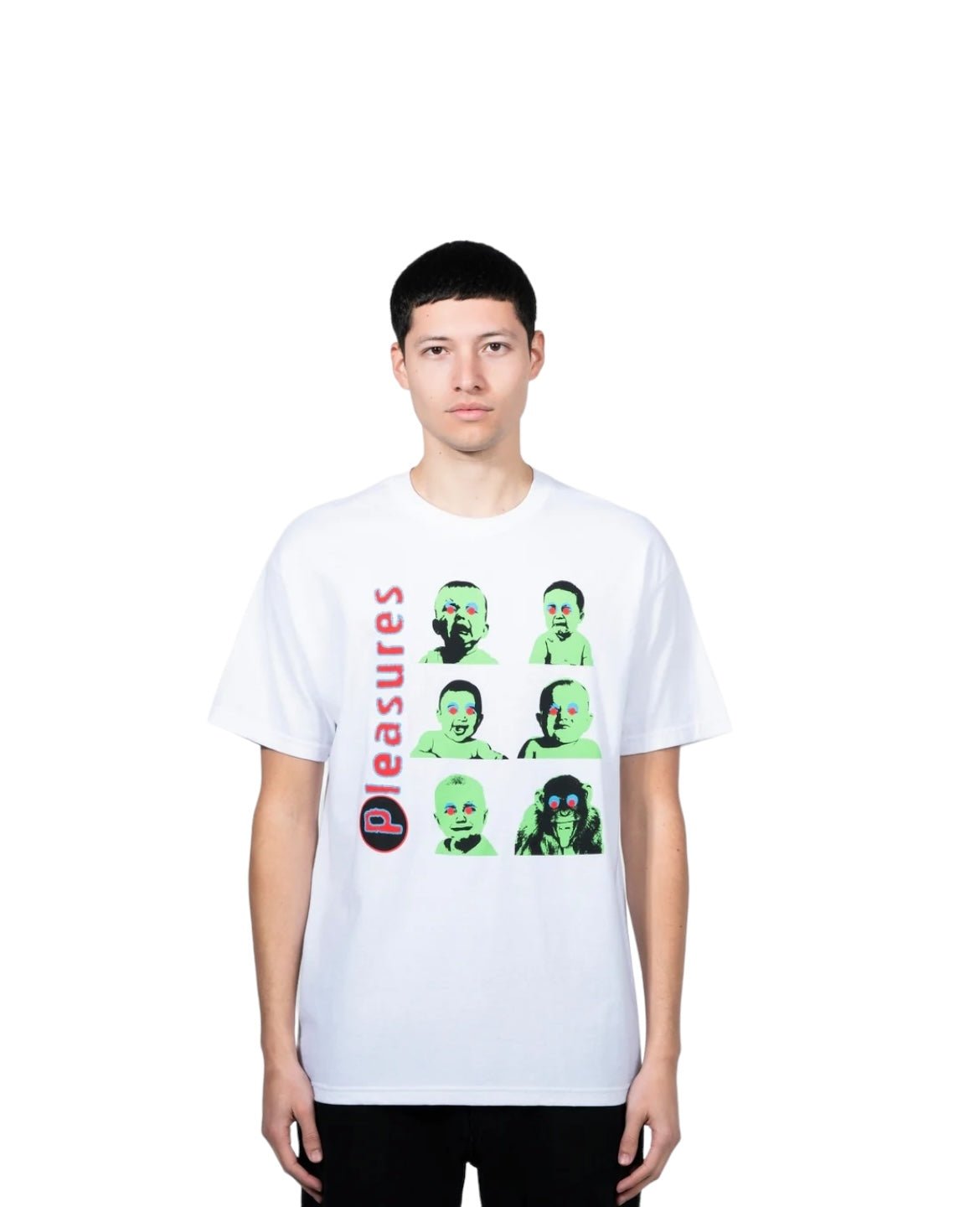 A person stands wearing a white PLEASURES PLEASURES HEAD T-SHIRT WHITE, made from 100% cotton, featuring green and black graphic faces and the word "pleasures" in red, screen printed in the USA, displayed against a plain white background.