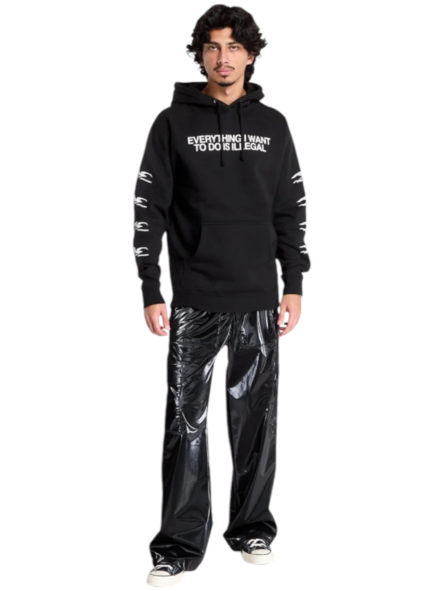 Someone wearing the Pleasures Illegal Hoodie Black from PLEASURES and shiny black polyester pants stands against a white backdrop.