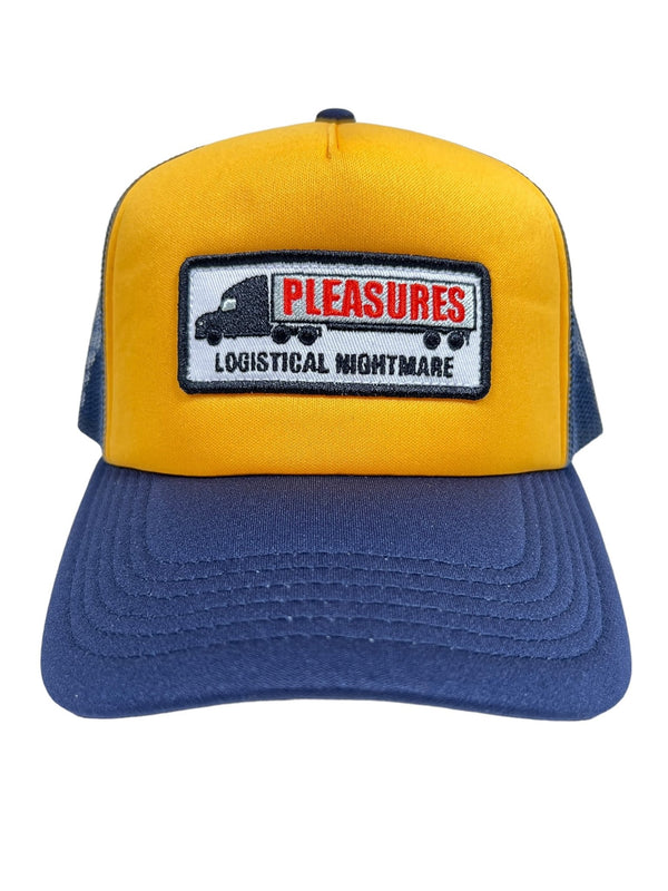 The PLEASURES NIGHTMARE TRUCKER NAVY/YELLOW hat from PLEASURES, made of durable polyester, features a rectangular patch on the front that reads "PLEASURES LOGISTICAL NIGHTMARE" alongside an image of a truck.