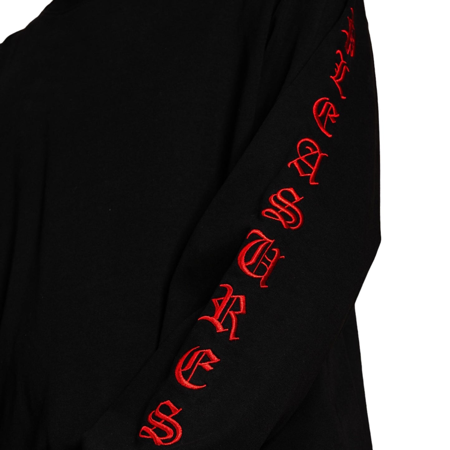 Black heavyweight cotton long sleeve by PLEASURES featuring red gothic satin stitch embroidery along the sleeve spelling "TREASURES.