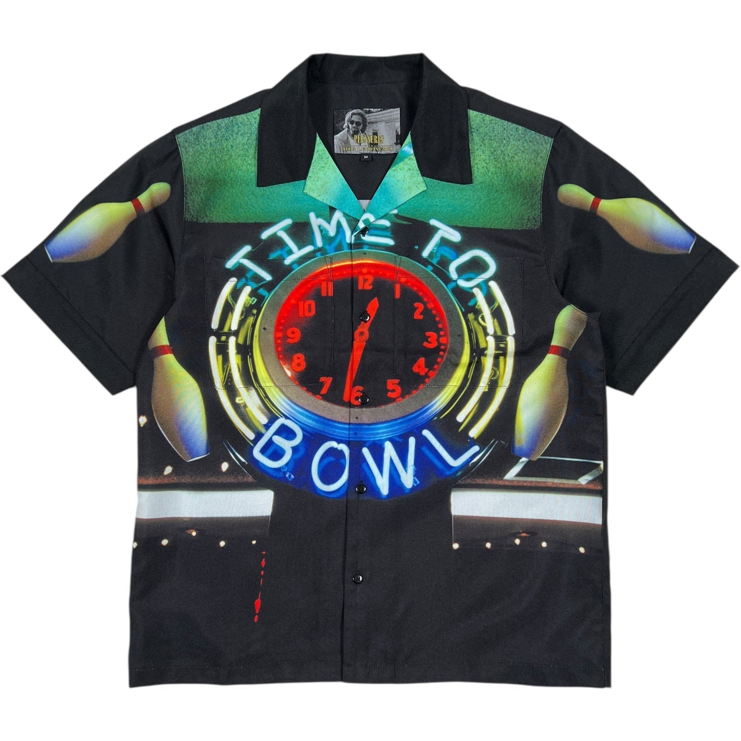 The PLEASURES Time Bowling Button Up Black is a polyester short-sleeve shirt with a clock at 12:00, neon "TIME TO BOWL" text, and bowling pins on black—a classic look from PLEASURES.