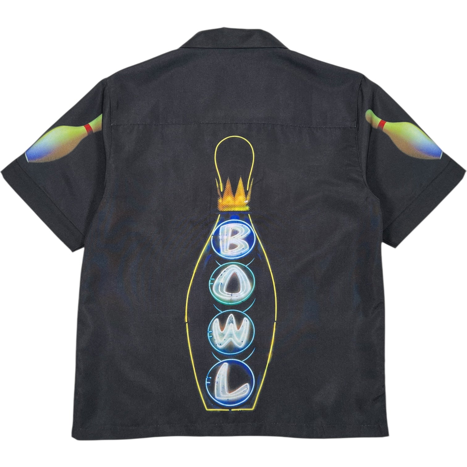 The PLEASURES Time Bowling Button Up Black is a short-sleeve polyester shirt featuring neon-style “BOWL” and pin graphics on the back, plus playful bowling pin designs on both sleeves.