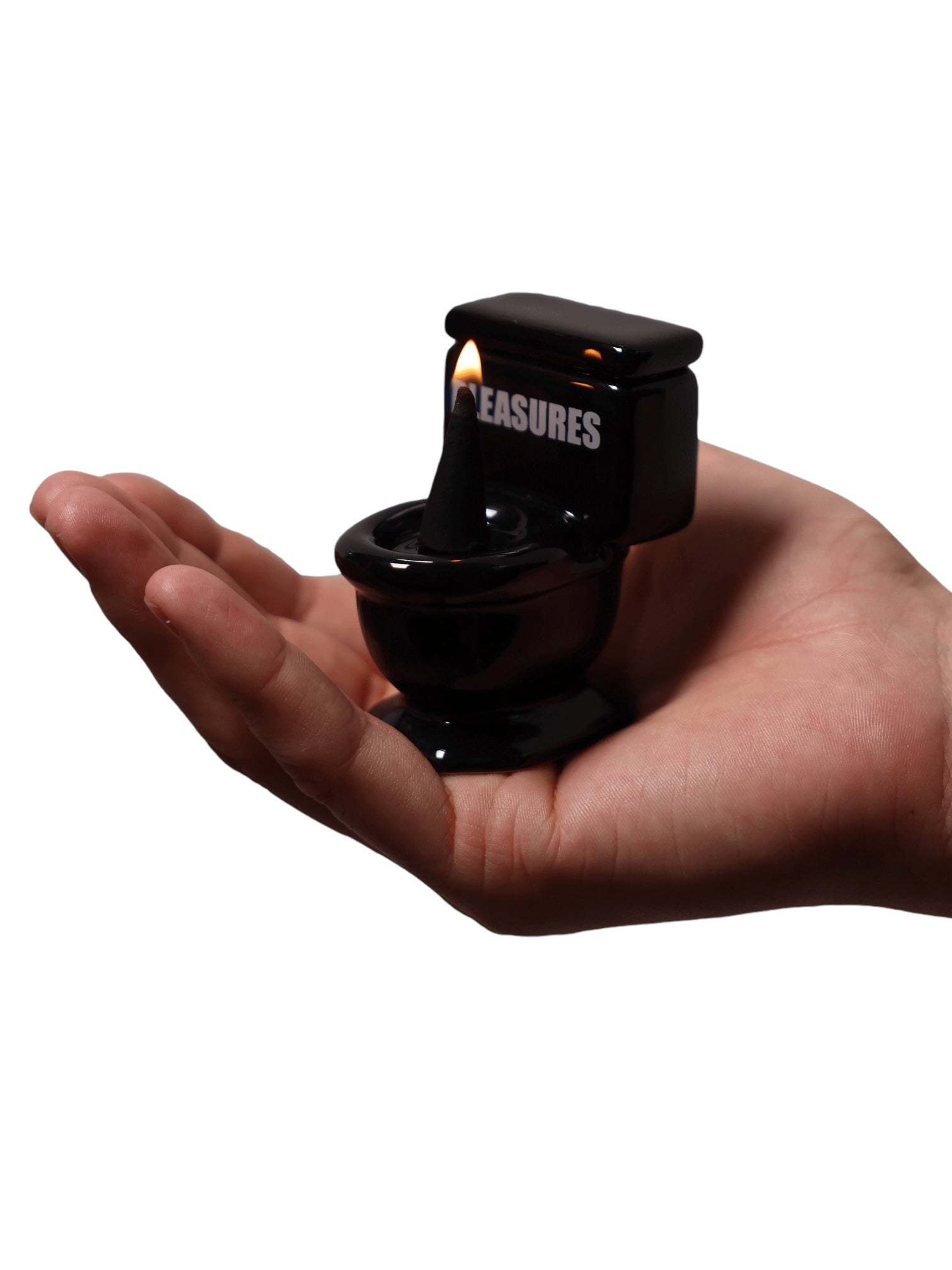 A hand holds the PLEASURES Toilet Cone Burner in Black, with a burning cone incense inside, ideal for elevating your self-care regimen.