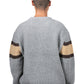A person faces away wearing the Pleasures Twitch Chunky Knit Sweat Grey by PLEASURES, featuring brown and beige striped sleeves. With a shaved head, they add to the cozy vibe of this wool blend garment.