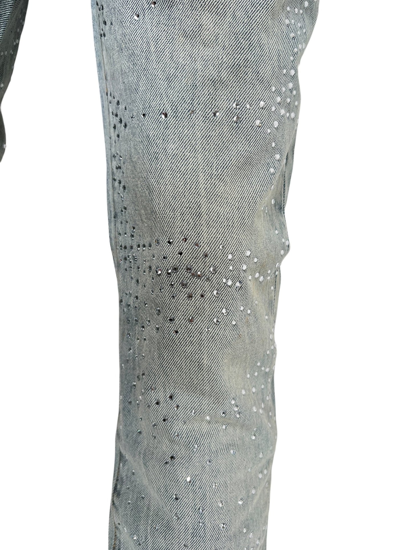 Close-up of a person's leg wearing PURPLE BRAND P001-SALT425 Skinny Atlin Blitz Indigo jeans, made from premium stretch denim with scattered small silver rhinestone embellishments.