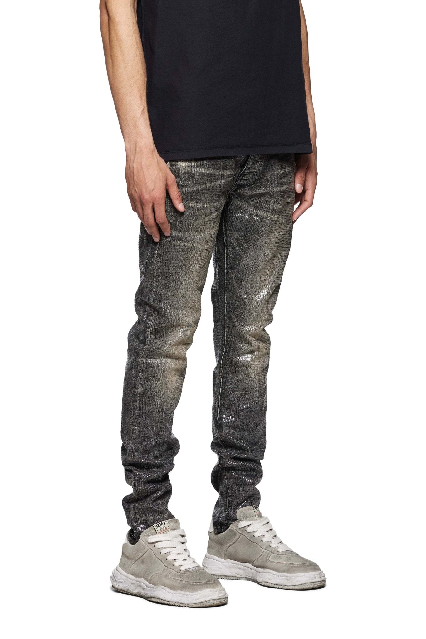 A person wearing a Purple Brand P001-TOBL Tiled Overlay Black shirt, premium stretch denim distressed gray jeans, and gray sneakers stands against a white background.