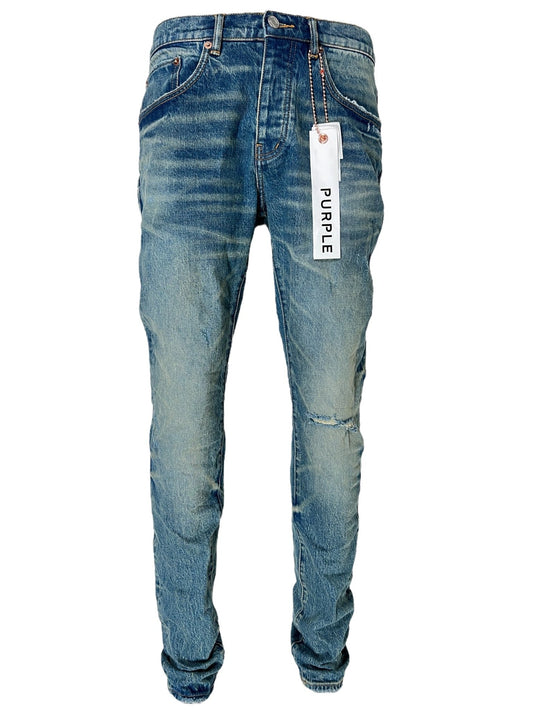 A pair of blue distressed jeans with a PURPLE BRAND hangtag attached to the belt loop, crafted from premium stretch denim for ultimate comfort, specifically the PURPLE BRAND P001-VKMD VINTAGE KNEE BLOWOUT MID INDIGO model.