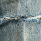 A close-up of a frayed seam on the Purple Brand P004-GBMF Gaia Blowout Flare Indigo Denim offers a sophisticated glimpse into PURPLE BRAND's Spring/Summer 2025 collection, highlighting the wear and texture of the indigo fabric.