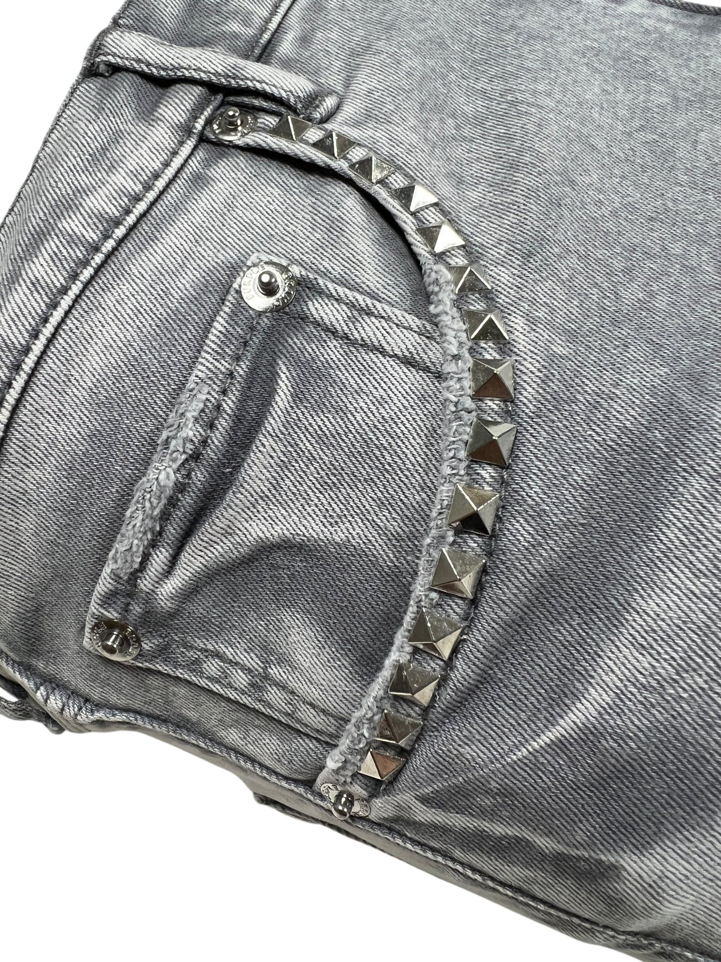 Close-up of the PURPLE BRAND P005-AYDG325 Alloy Studs Overdyed Grey: features a metallic silver stretch denim pocket with pyramid-shaped metal studs along the seam and a snap button on the flap.