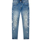 The Purple Brand P005-MGPI Manganese Paint Emb Indigo jeans feature a medium indigo wash with a faded design and paint splatter effect, crafted in premium stretch denim.
