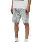 Only the lower half of a person is visible, wearing a printed white t-shirt, PURPLE BRAND P059-GRPS325-Grunge Print Shorts in Indigo, white socks, and brown sneakers.