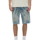 Wearing a textured cream t-shirt, relaxed fit, PURPLE BRAND Purple Brand P059-MXPS Mixed Paint Shorts Indigo, white socks, and white sneakers, a person stands against a plain background.