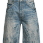 The Purple Brand P059-MXPS Mixed Paint Shorts in Indigo are relaxed-fit, distressed denim shorts featuring a button closure, front pockets, and a faded, worn look.
