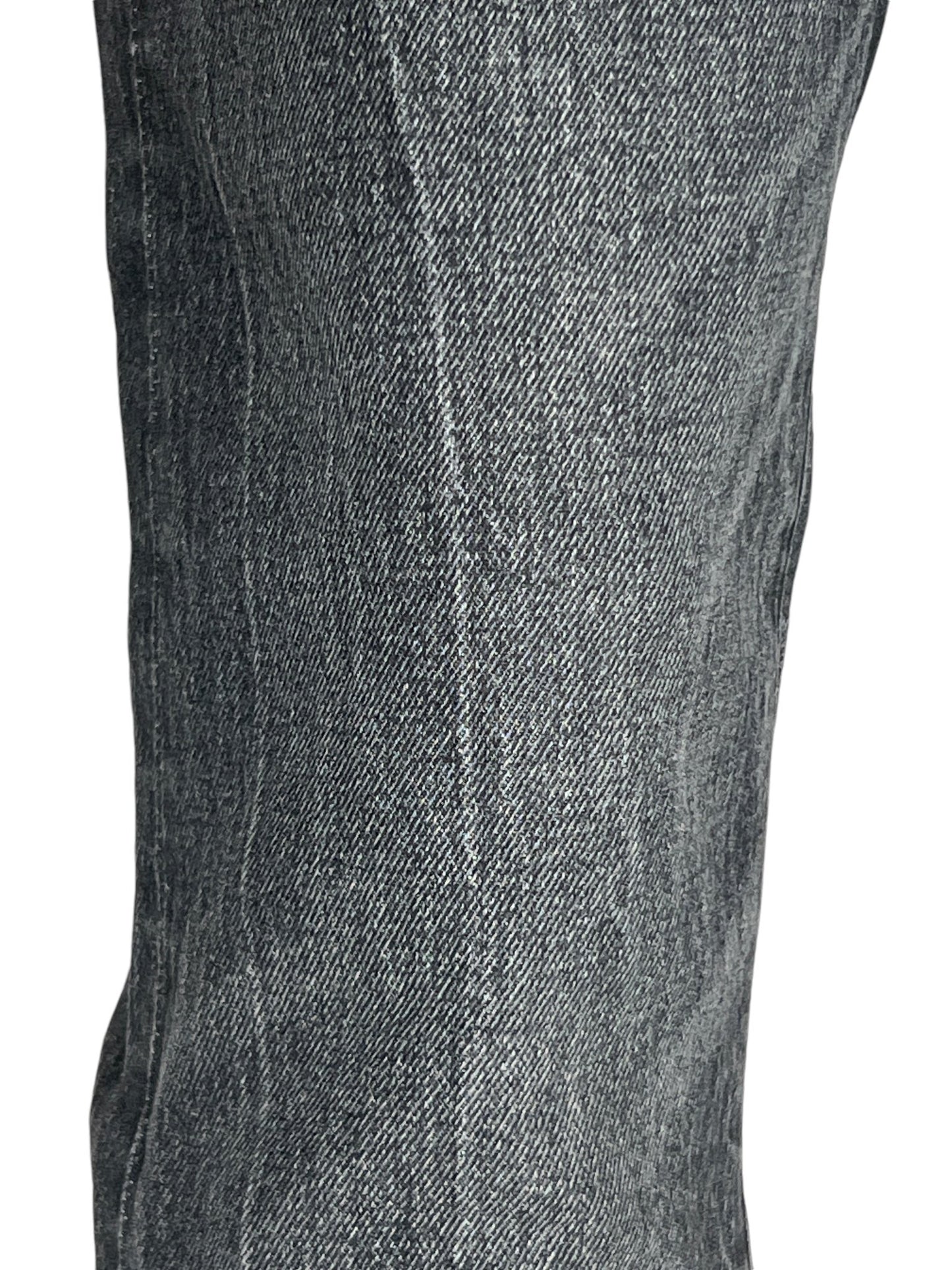 Close-up view of a person wearing the PURPLE BRAND P072-SSVB Super Stack Flare Coated Black jeans, focusing on the texture and weave of the fabric.