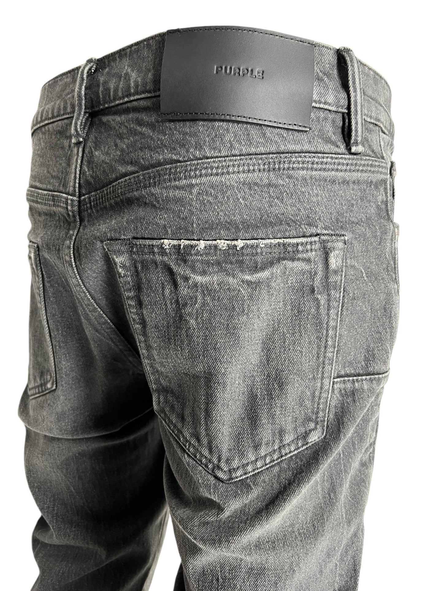 Close-up image of the back of a pair of faded, coated black PURPLE BRAND P072-SSVB SUPER STACK FLARE jeans with visible stitching and a sleek black leather patch on the waistband displaying the word "Purple" by PURPLE BRAND.