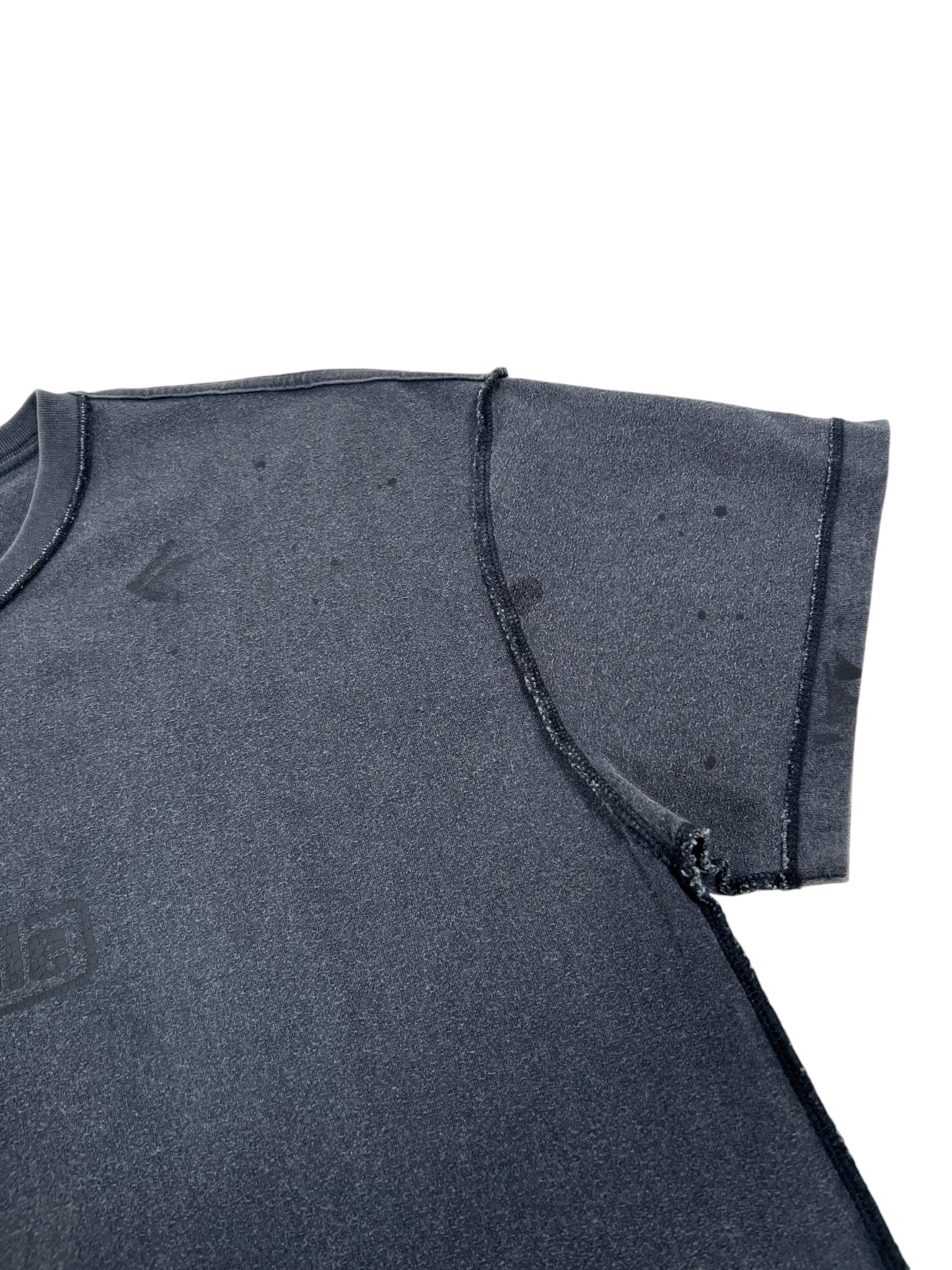 The Purple Brand P101-JBCP Textured Inside Out Tee BLK from PURPLE BRAND is a black short-sleeve T-shirt highlighting textured, slightly shiny 100% cotton fabric. Visible stitching marks the seams, complemented by subtle dark spots on its surface.