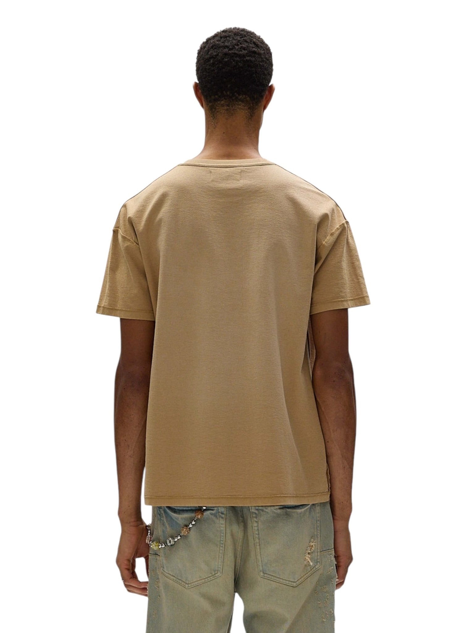 A person is seen from the back wearing a PURPLE BRAND P101-JTGU Textured Inside Out Tee in tan, paired with light blue distressed jeans. A stylish keychain hangs from the waist, adding flair to the casual look.