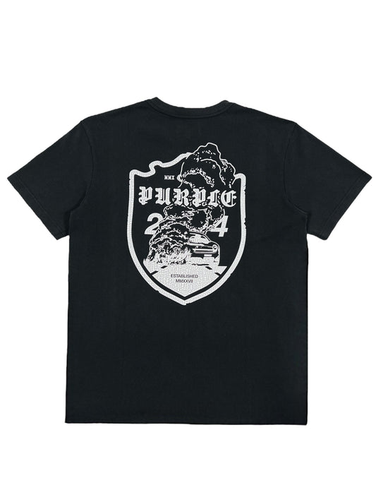 The PURPLE BRAND P117-HWBB HWT JERSEY SS TEE BLACK features a striking large white design on the back, depicting mountains, a car, and the text 'PURPLE 2024' inside a shield-shaped motif. Made from 100% cotton, this black graphic t-shirt combines comfort with style for a bold statement piece.