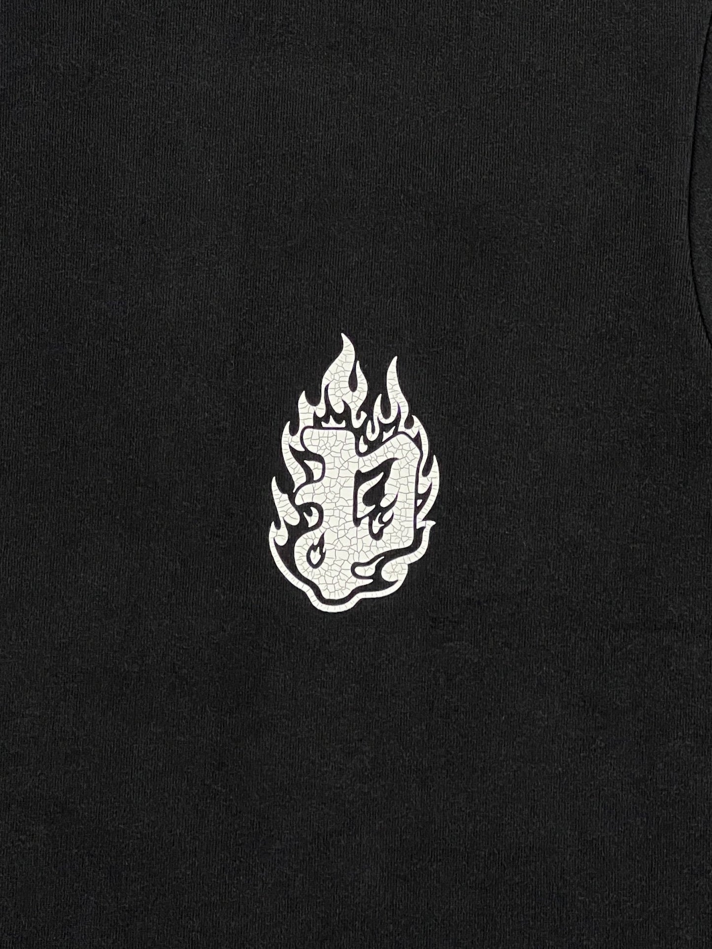 The PURPLE BRAND P117-HWBB HWT Jersey SS Tee in Black, crafted from 100% cotton, features a white flame emblem with intricate patterns and is enhanced by a subtle tie-dye effect.