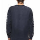 Back view of a person with braided hair wearing a Purple Brand P204-JWGW Textured Jersey Ls Tee in black, featuring white text on the sleeves and paired with light blue jeans. The gothic PURPLE BRAND logo adds an edgy touch.