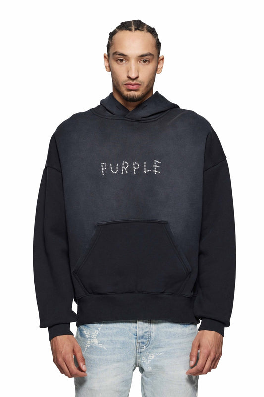 A person is wearing the Purple Brand P401-HBSS HWT Fleece PO Hoody in black with "PURPLE" boldly displayed on the front, stylishly paired with light blue jeans.