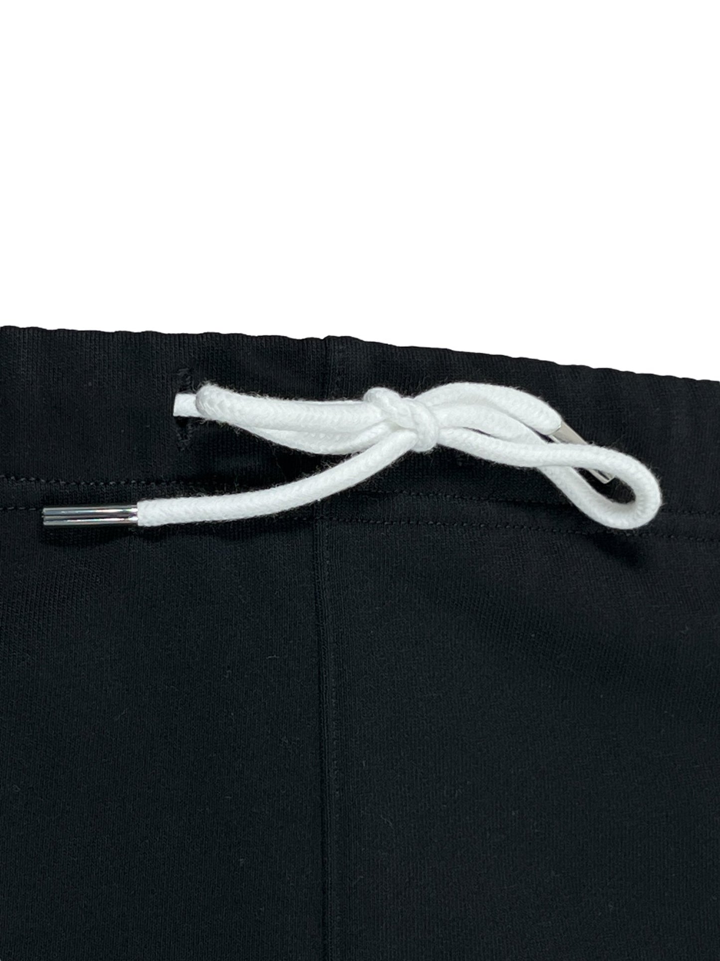 Close-up of a white drawstring tied into a bow on black PURPLE BRAND P446-FCBB FRENCH TERRY SWEATSHORT BLK fabric, with metal aglets on the string ends.