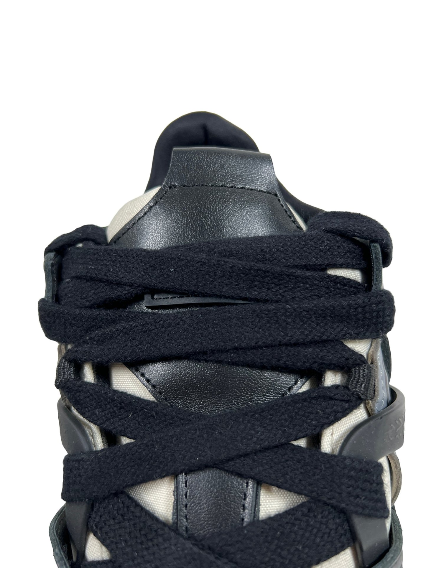 Close-up of a REPRESENT M12068-37 BULLY LEATHER BLACK sneaker with black leather detailing and ballistic nylon mesh upper, viewed from the front top, isolated on a white background.