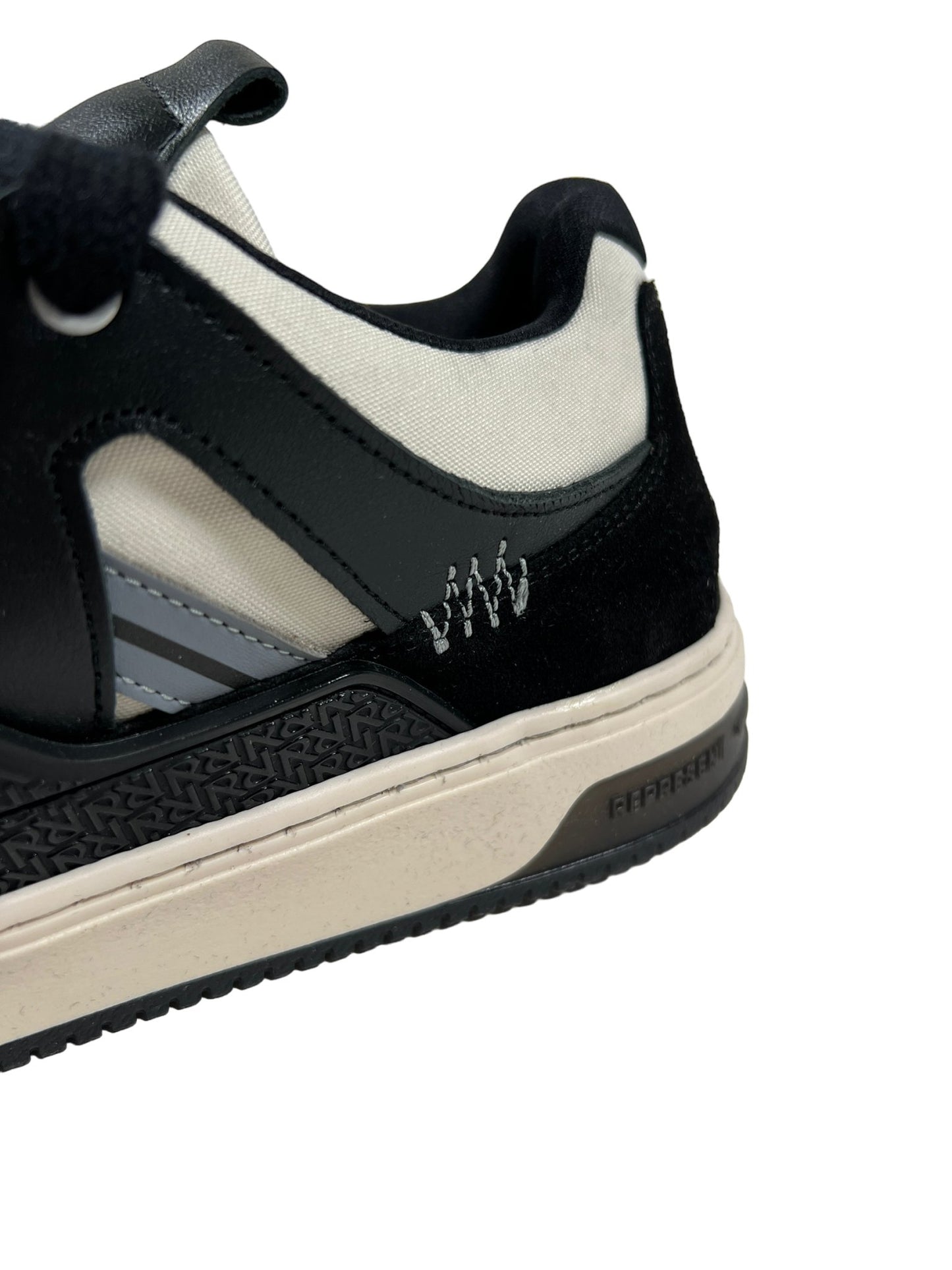 Close-up of a REPRESENT REPRESENT M12068-37 BULLY LEATHER BLACK sneaker detailing suede and fabric textures, with a small logo on the side.