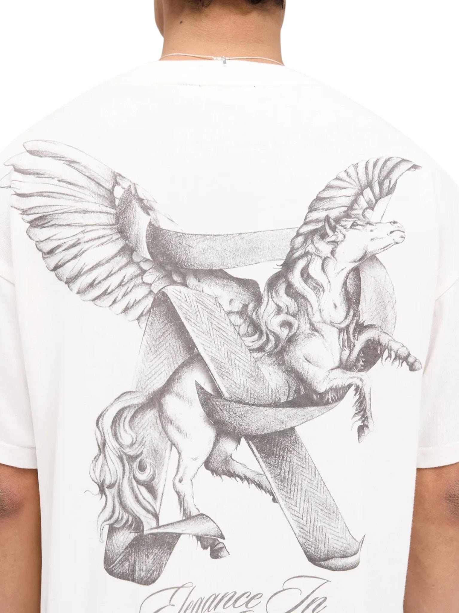 A person is seen from behind wearing the Represent MLM41066 Elegance in Motion Tee in White. The tee features a winged horse, a flowing mane intertwined with a ribbon, and is crafted by REPRESENT from soft jersey cotton for both comfort and style.