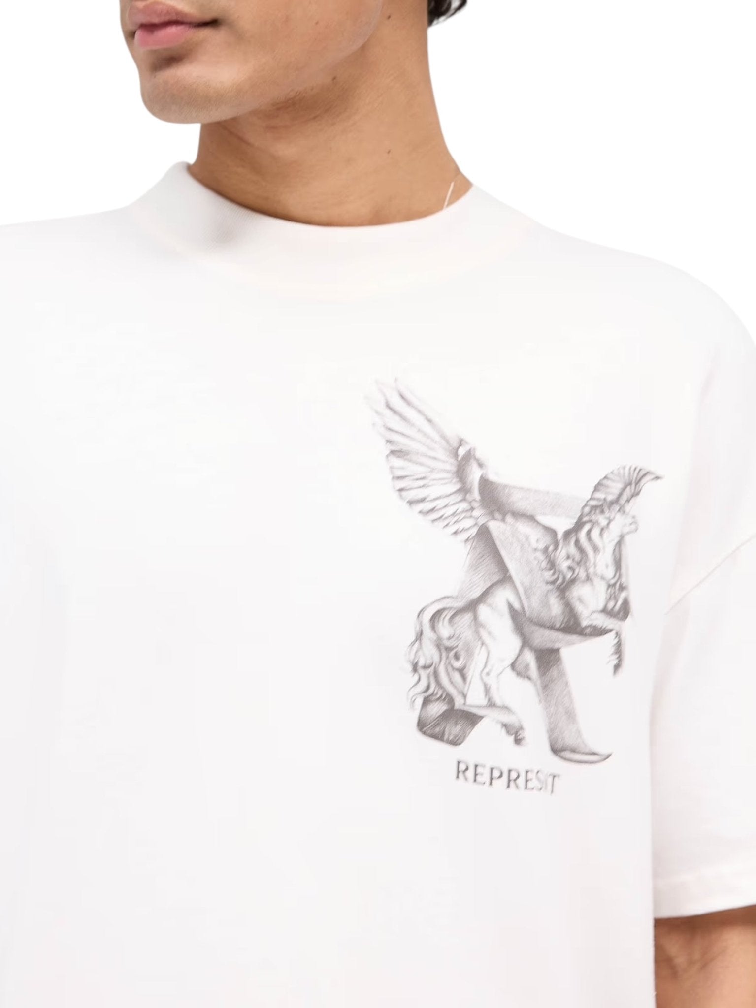 The individual is dressed in a soft jersey cotton Represent MLM41066 Elegance in Motion Tee in White, featuring a winged horse design and "REPRESENT" on the front.