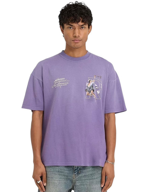 A person wearing an oversized Represent MLM4228 Hermes T-shirt in purple by REPRESENT, featuring a high-density screen print graphic, and jeans stands against a plain white background.