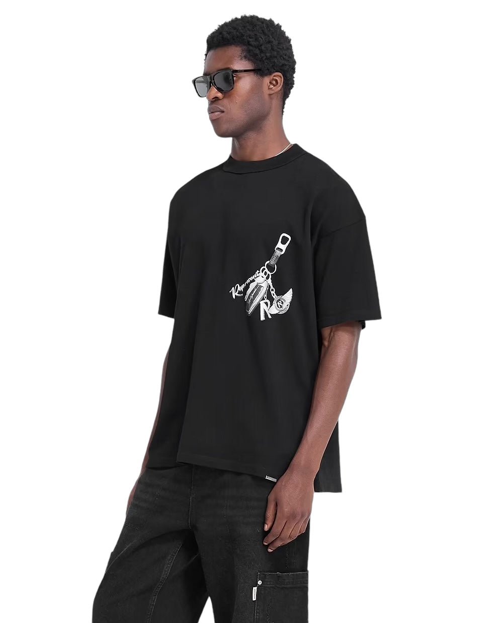 A person wearing the Represent MLM4236 Keys To The Club T-Shirt in Jet Black from REPRESENT, along with black pants and sunglasses, stands against a white background.