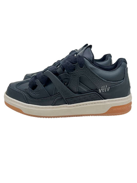 The Represent MLM9599 BULLY BLACK/GUM sneakers from REPRESENT showcase a triple black design with a leather upper, highlighted by white stitching details. These stylish shoes are completed with black laces and brown rubber soles on a white background.